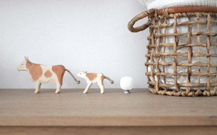 ecobee's SmartSensor placed on a shelf next to a wicker basket and animal figurines .
