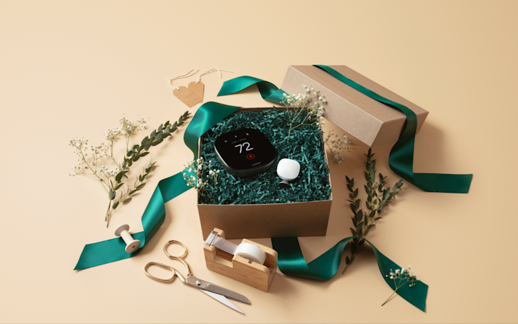 ecobee's Smart Thermostat Premium in holiday packaging in a brown gift box and green ribbon.