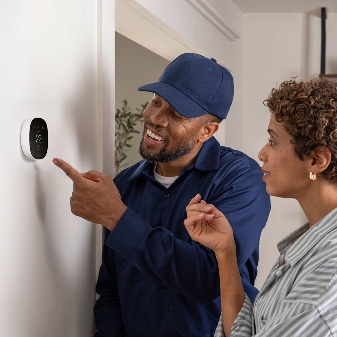 HVAC technician shows a homeowner how to use an ecobee thermostat