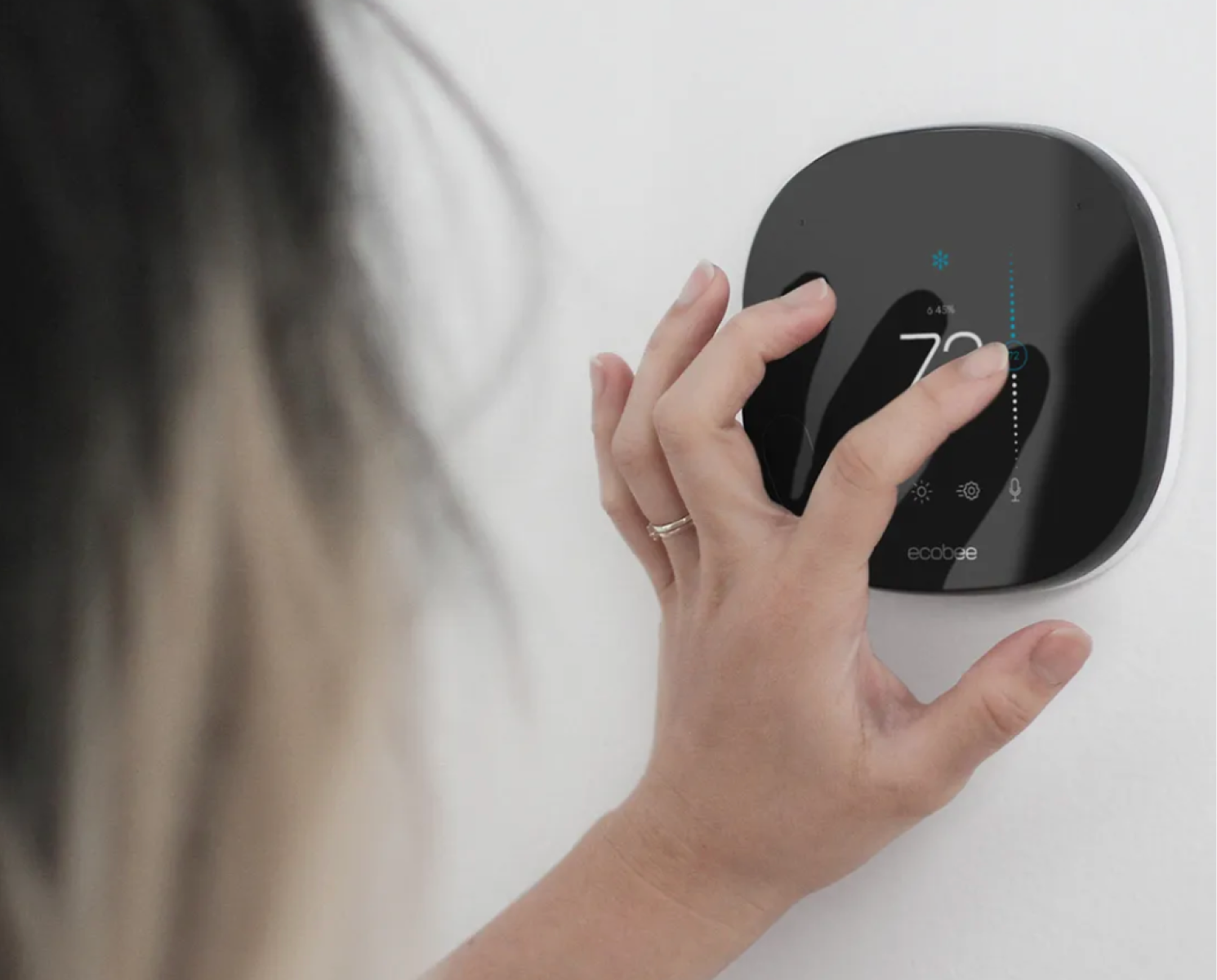 a hand adjusting the temperature on an ecobee thermostat