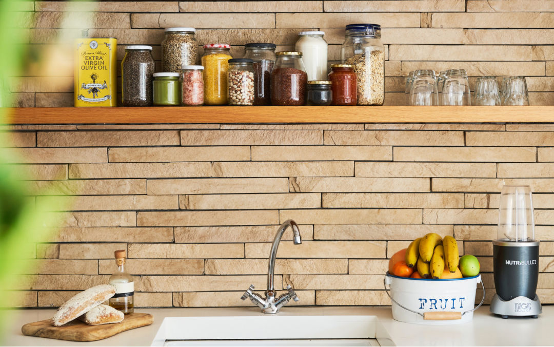 Beautifully organized shelf with spices in jars above a sink.