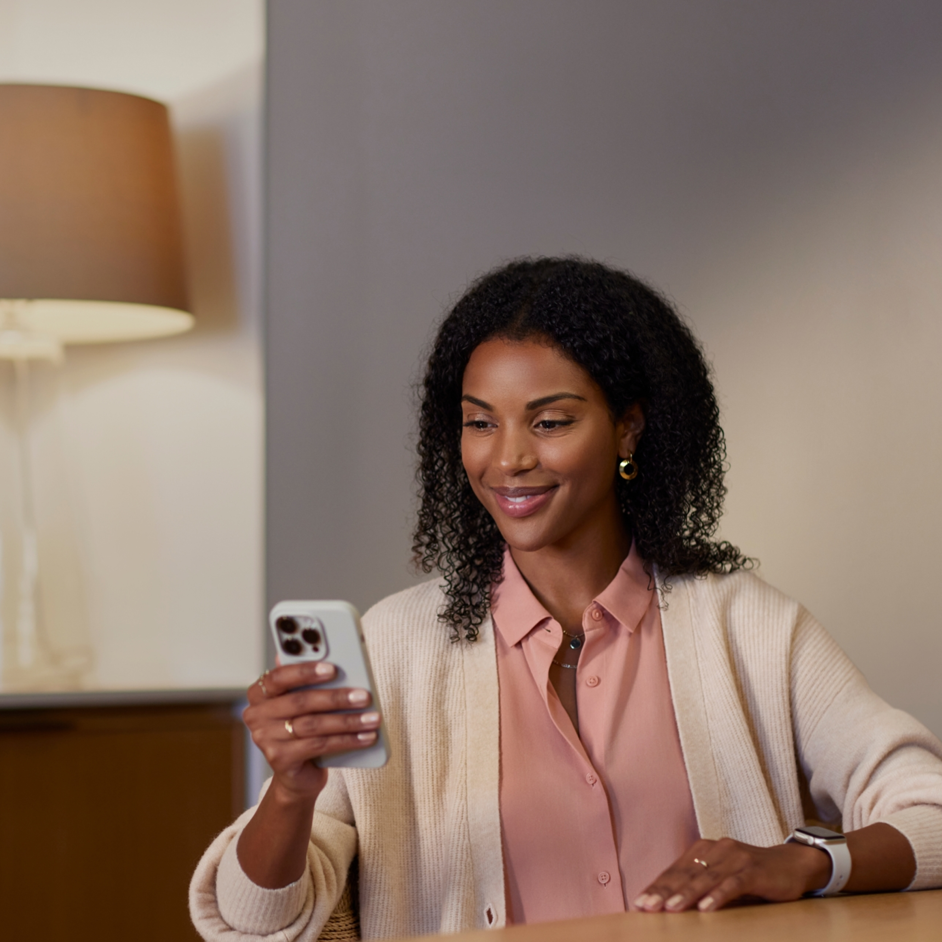 Une main tient un téléphone, l'écran affiche une notification de l'application ecobee