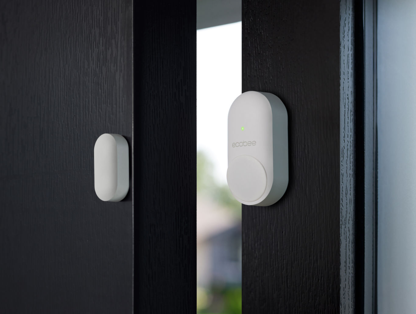 ecobee SmartSensor for doors and windows attached to a dark wooden door and door frame