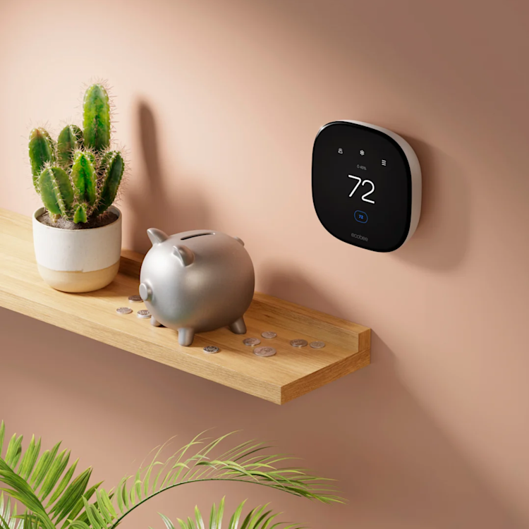 a piggy bank with coins sits on a shelf under an ecobee thermostat