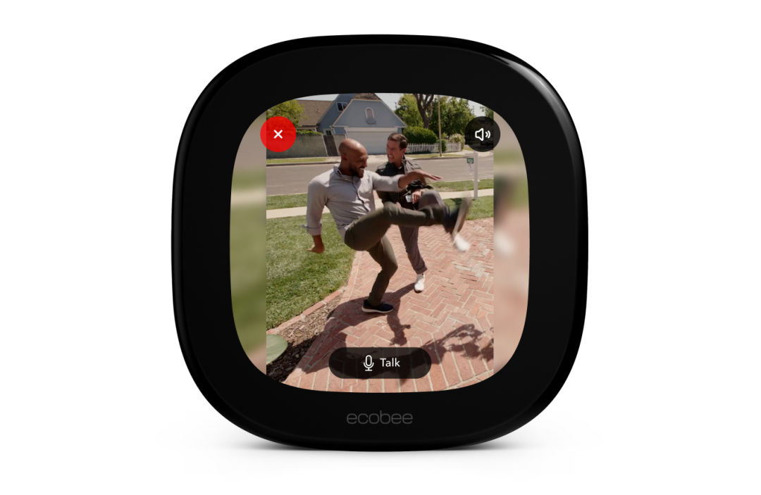 A thermostat screen shows two men practicing kicks on a driveway, captured by a doorbell camera. 
