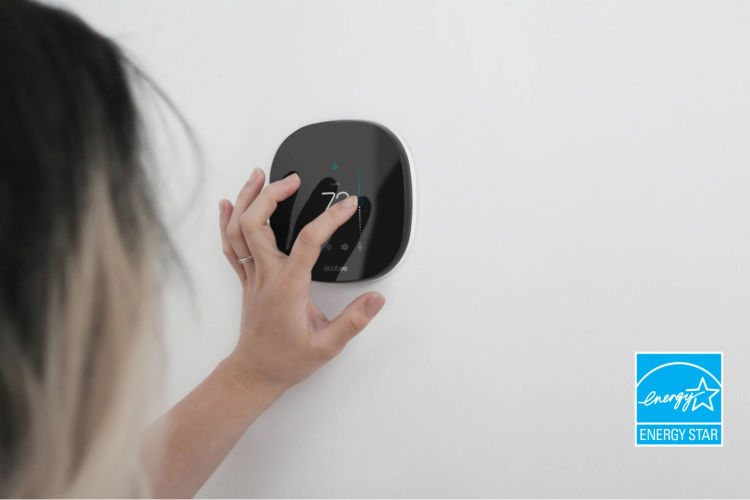 Woman adjusting ecobee thermostat, with ENERGY STAR logo in corner of image.
