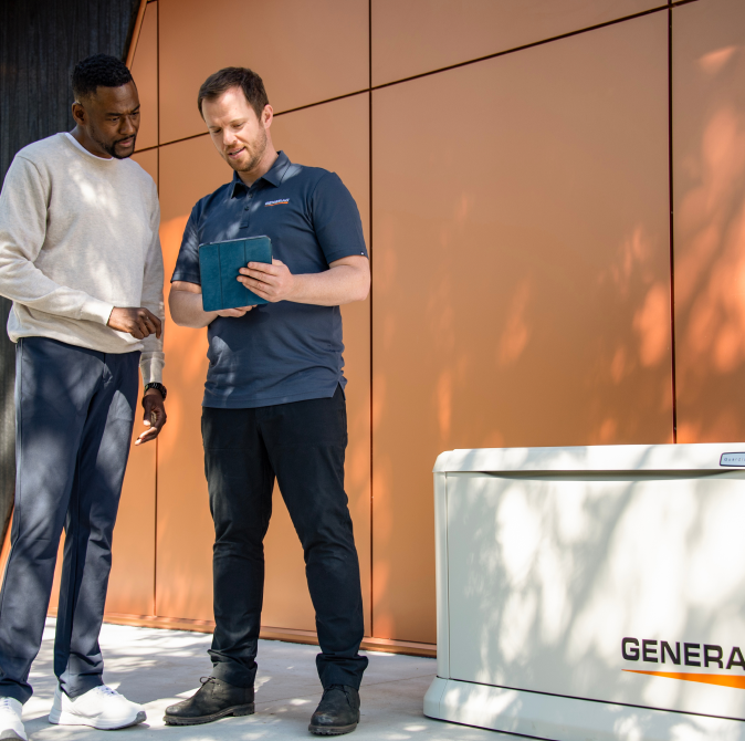 a generac technician shows someone how to use a generator