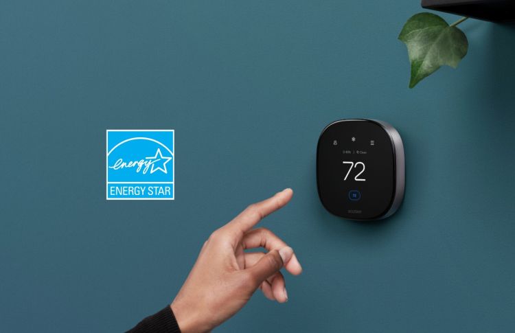 A hand reaching out to touch the ecobee smart thermostat