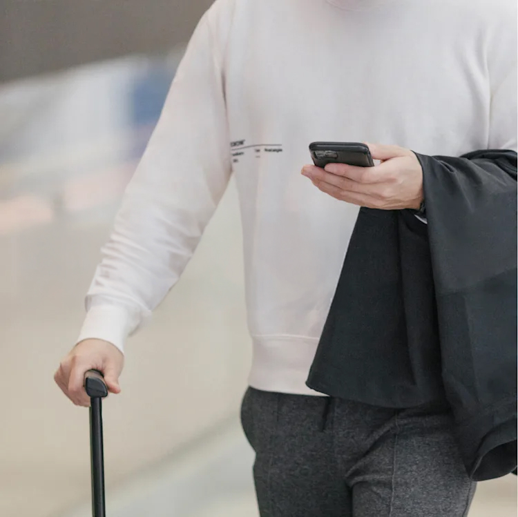 Une personne consulte son téléphone, qui affiche une notification de l'application ecobee indiquant « Alerte d'avertisseur de fumée - mon domicile »