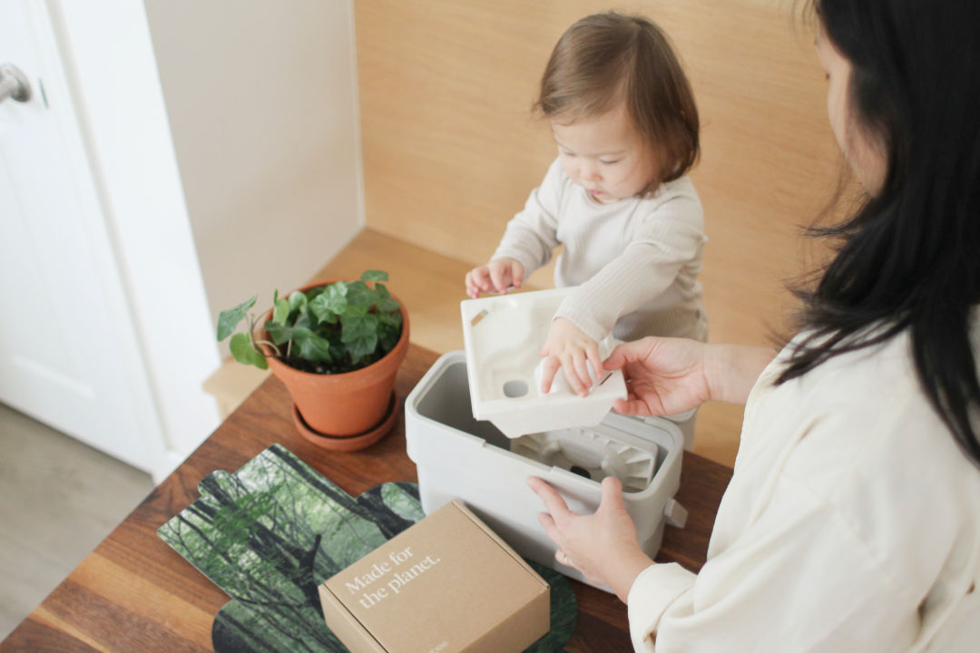 A woman and her toddler open an ecobee product