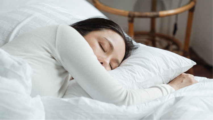 Woman sleeping on white sheets. 