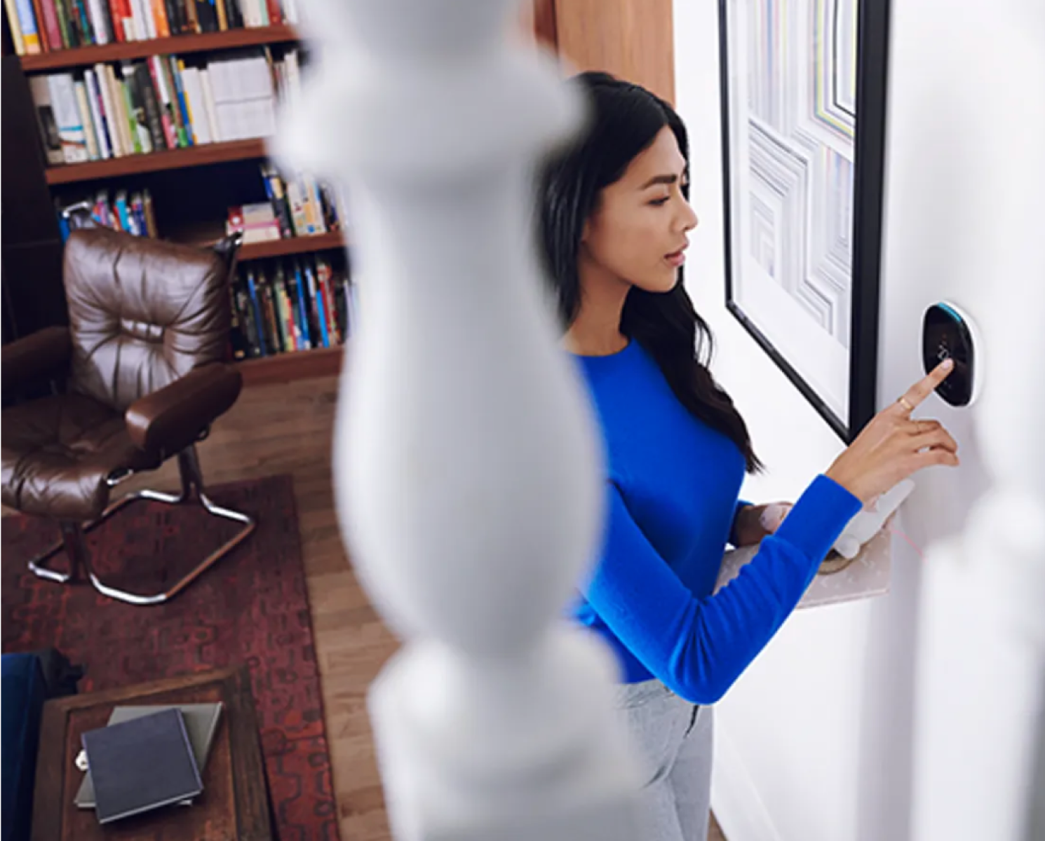 a woman adjusts her ecobee thermostat