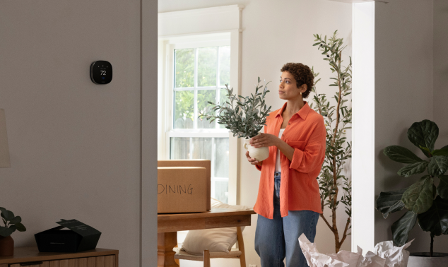 a person walks around a house with an ecobee thermostat on the wall