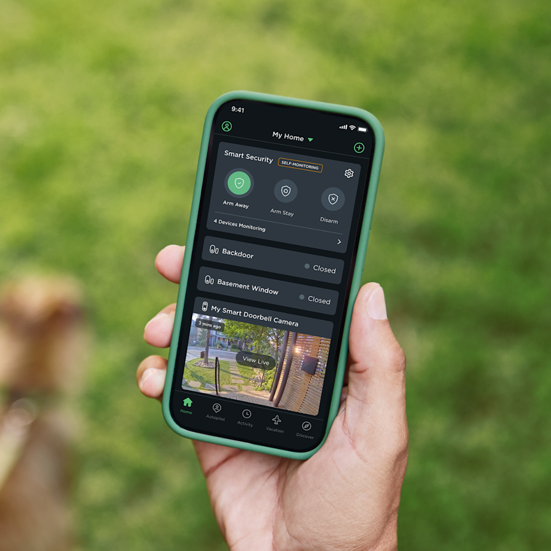 a hand holds a phone, the screen shows the ecobee app