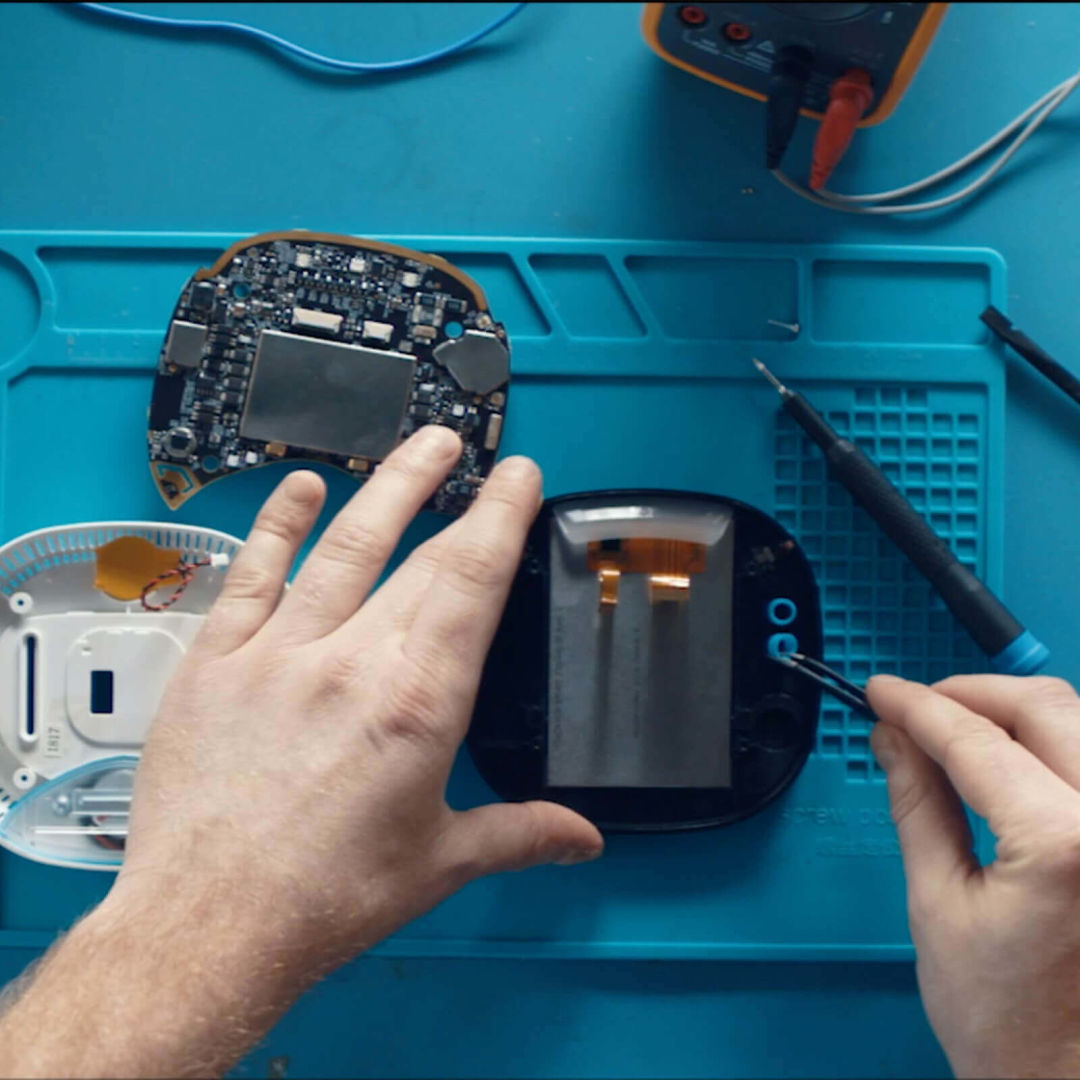  Technician  working on the machinery inside an ecobee smart thermostat.