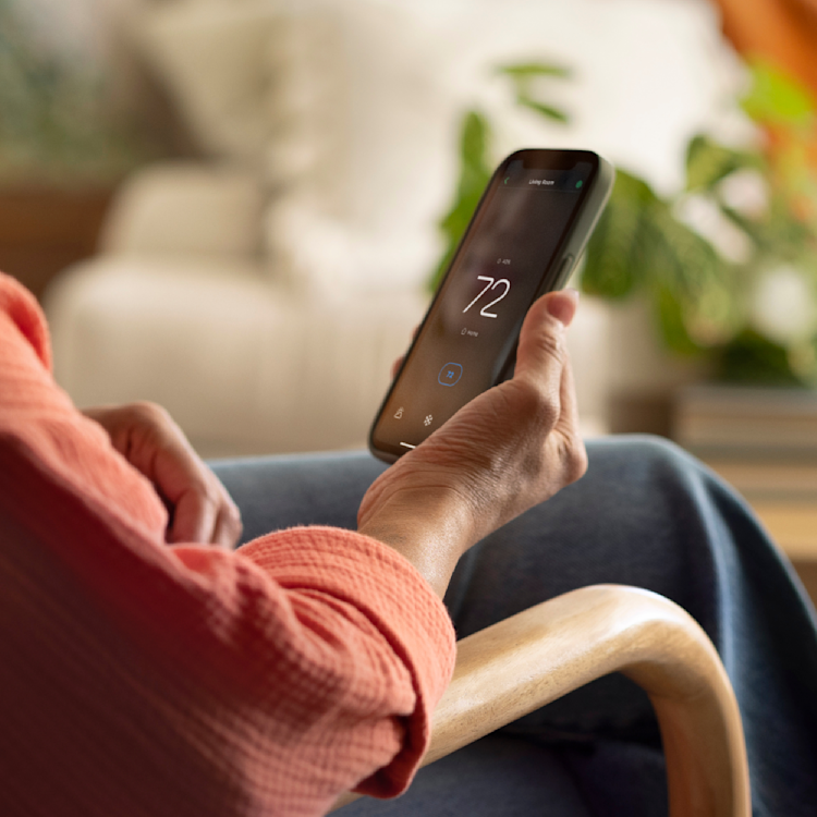 a hand holding a phone showing the ecobee app