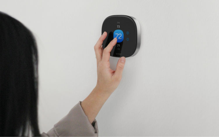 Woman changing temperature on Smart Thermostat Premium. 