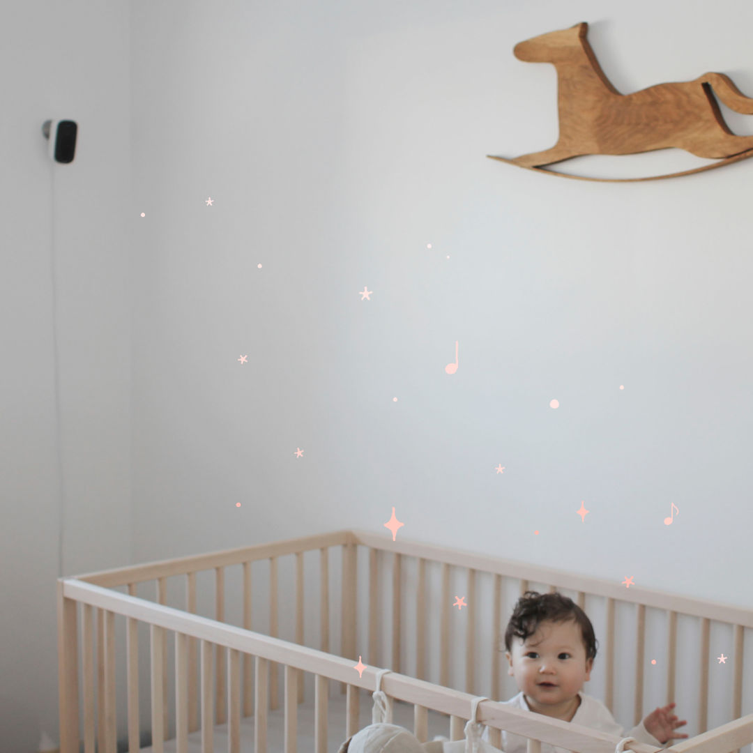 The ecobee SmartCamera is mounted on a wall above a crib with a baby in it.