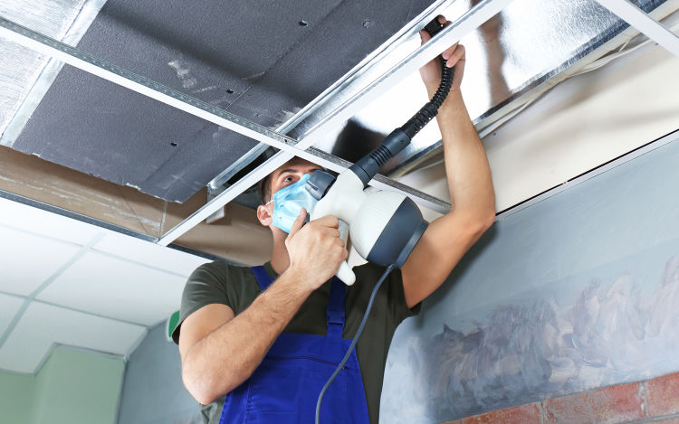 A man cleans the air ducts of a home.