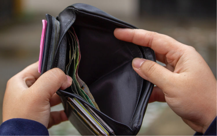 Close-up of a person looking inside their wallet.