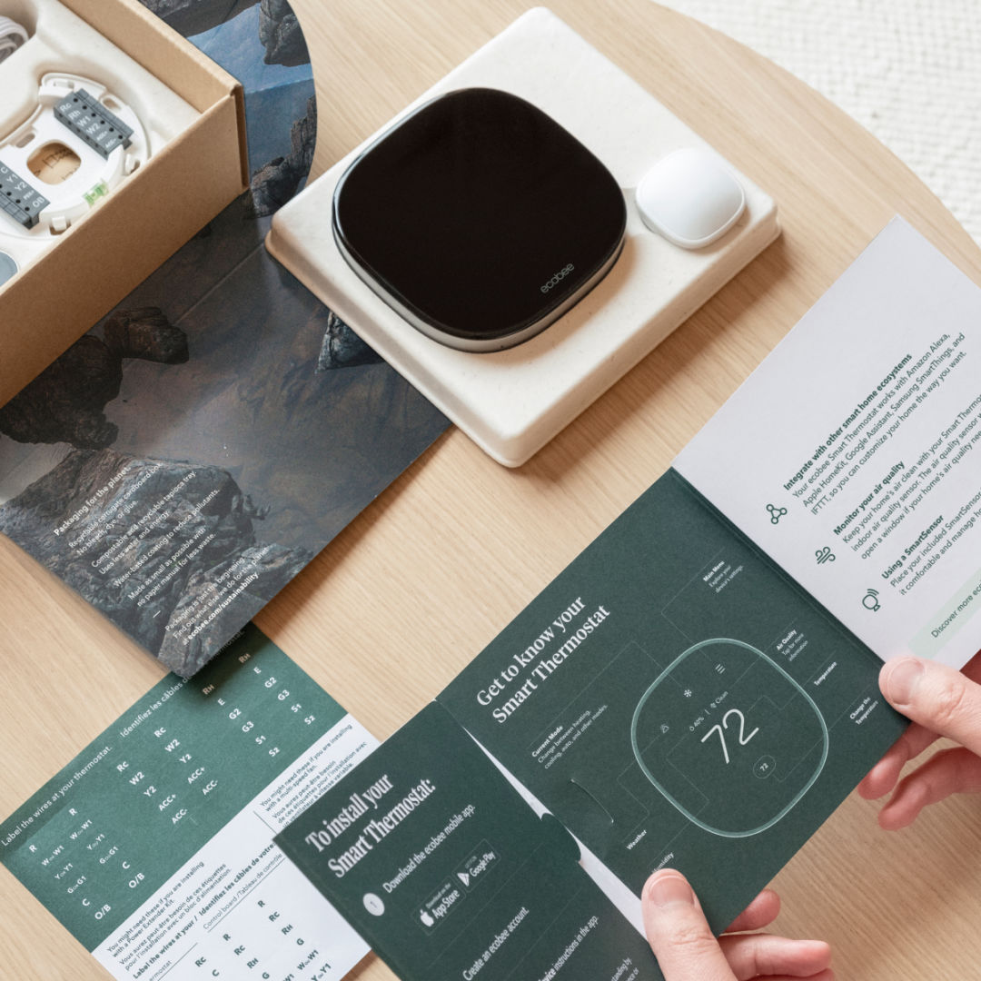 A person looks at the interior packaging of their ecobee Smart Thermostat Premium.