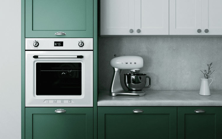 Green kitchen with stainless steel appliances and SMEG kitchen mixer.