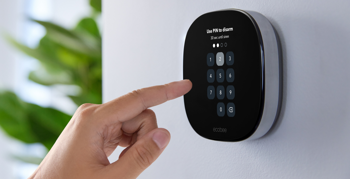 A hand uses the ecobee thermostat pin pad