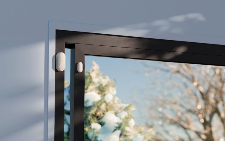 ecobee SmartSensors for Doors & Windows placed on the top left corner of door with a winter backdrop