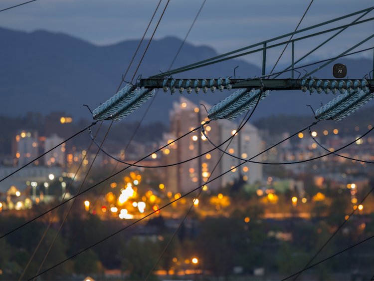 A view of an electrical grid in the early evening with the city in the background.