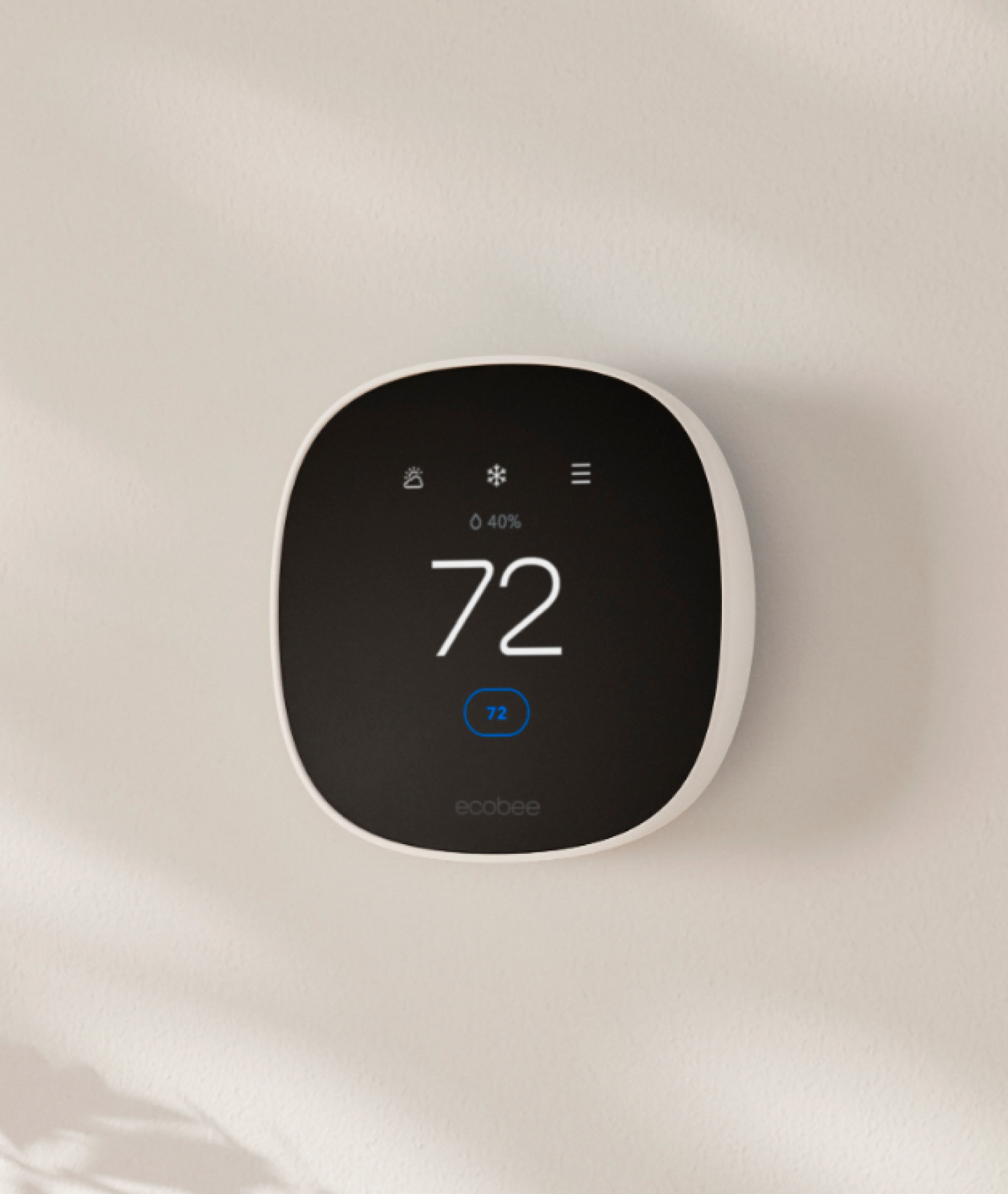 Side facing view of Smart Thermostat Essential on a beige wall