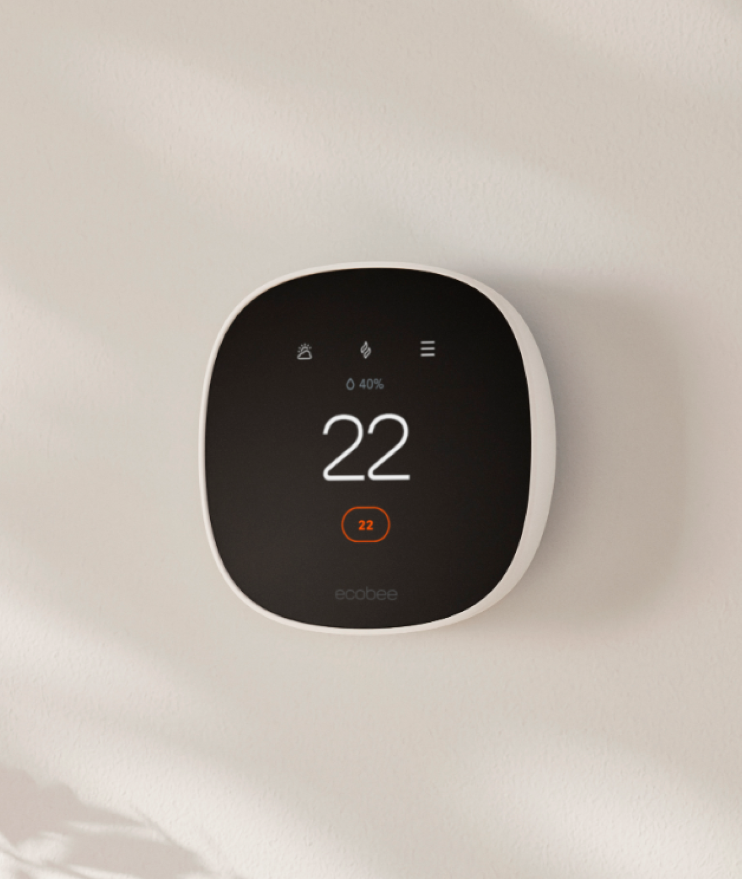 Side facing view of Smart Thermostat Essential on a beige wall