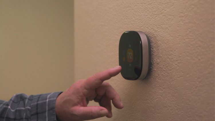 John Marlatt using an ecobee Smart Thermostat Premium installed on a wall