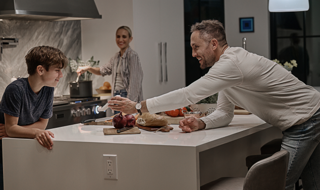 family in kitchen looks at phone screen