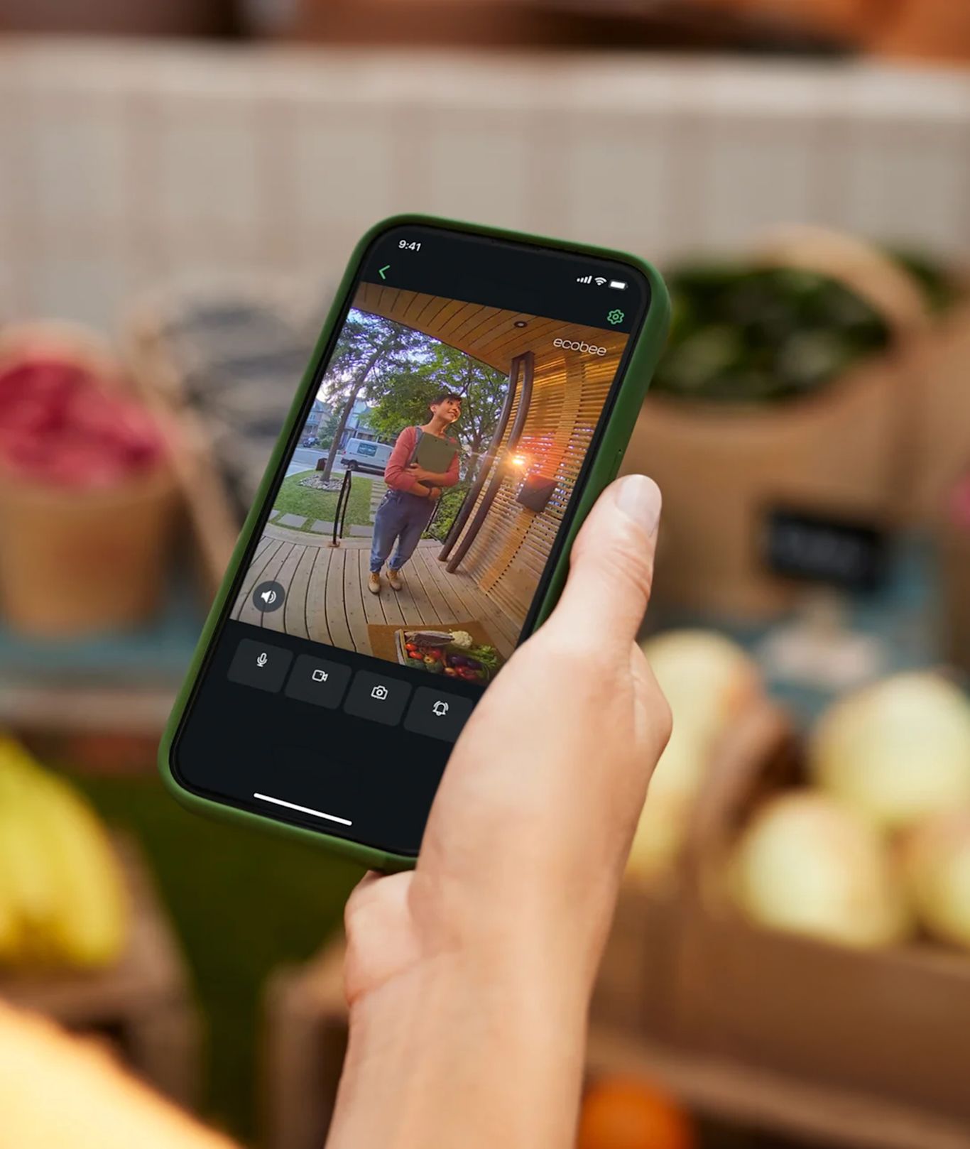 Une personne tient son téléphone avec une notification ecobee affichée à l'écran