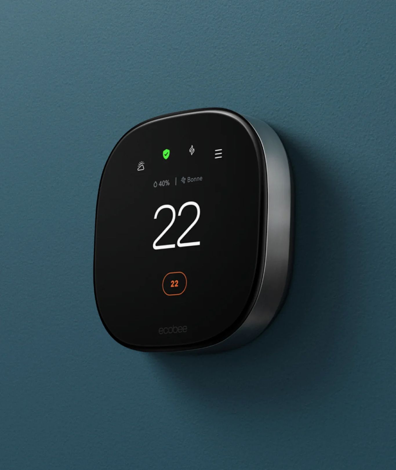 Un thermostat intelligent est monté sur un mur sarcelle foncé