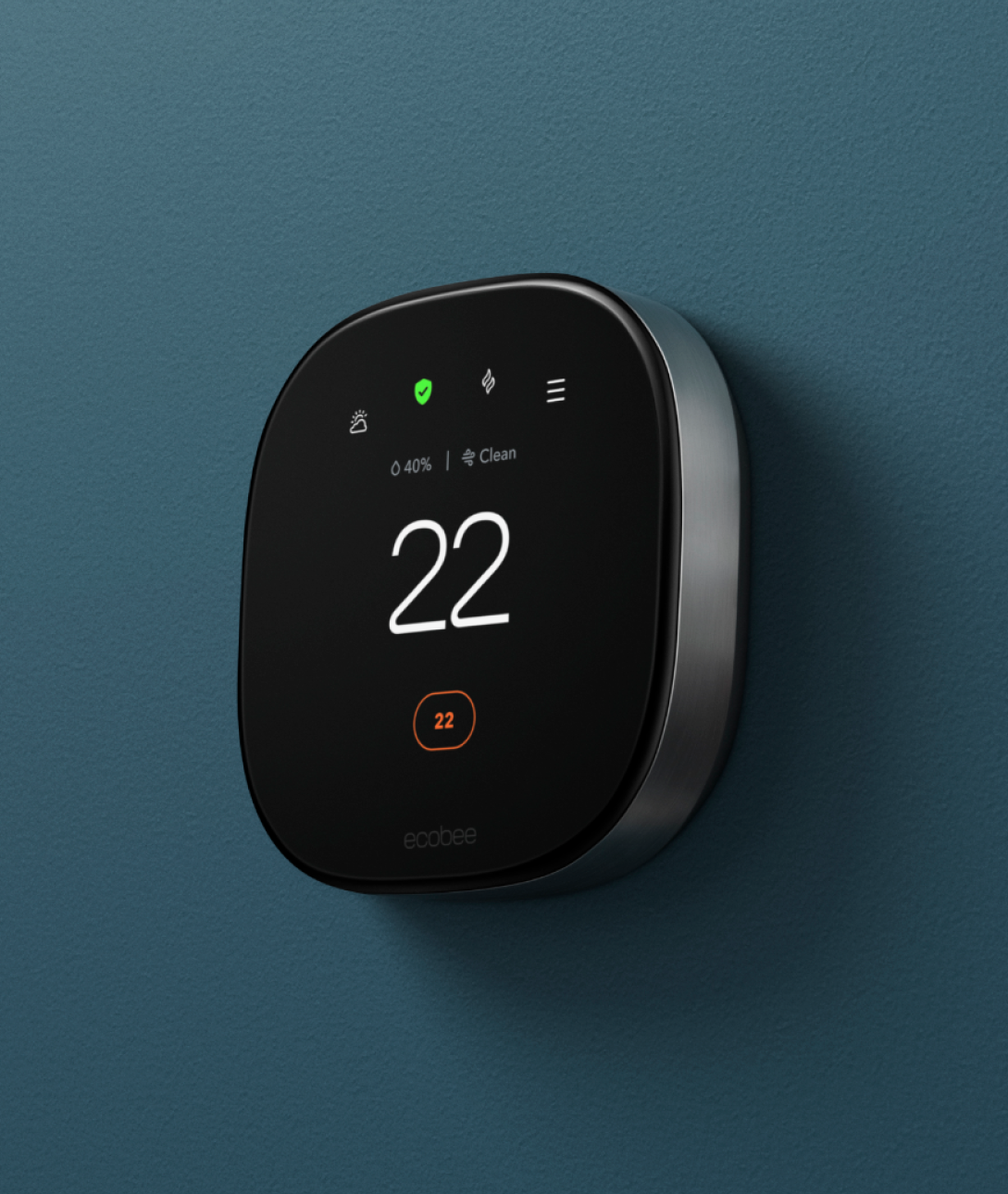 A smart thermostat is pictured mounted on a dark teal wall