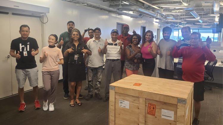 Nalini Ally and her colleagues at the ecobee headquarters in Toronto, posing with a crate filled with electronic devices.