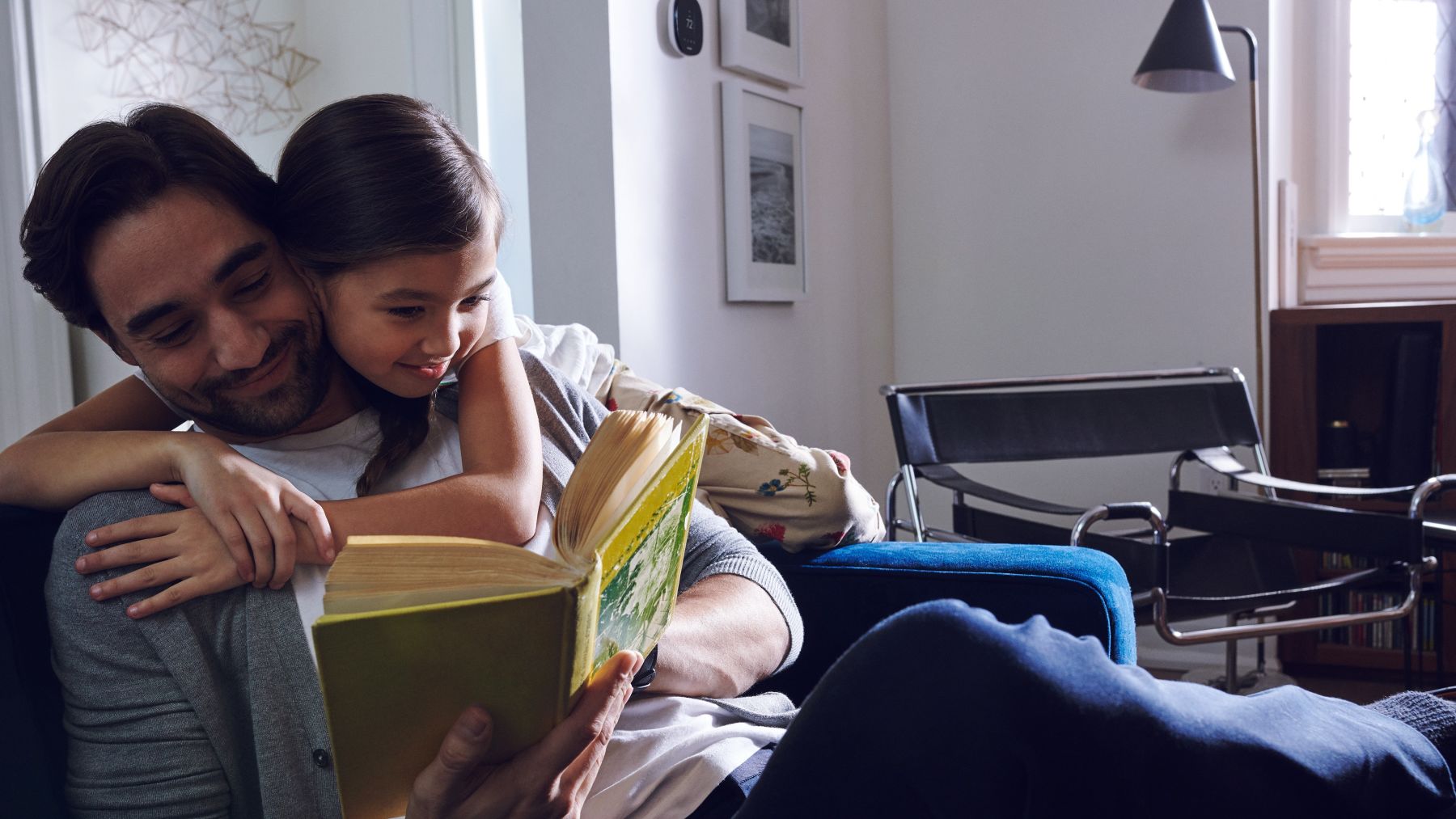 Father and daughter reading a book together to unwind.