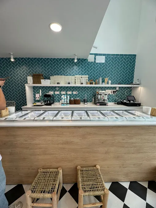 Mostrador de Bibi e Bibò López de Hoyos con vitrina de helados, pared de azulejos en espiga y decoración sencilla en madera.