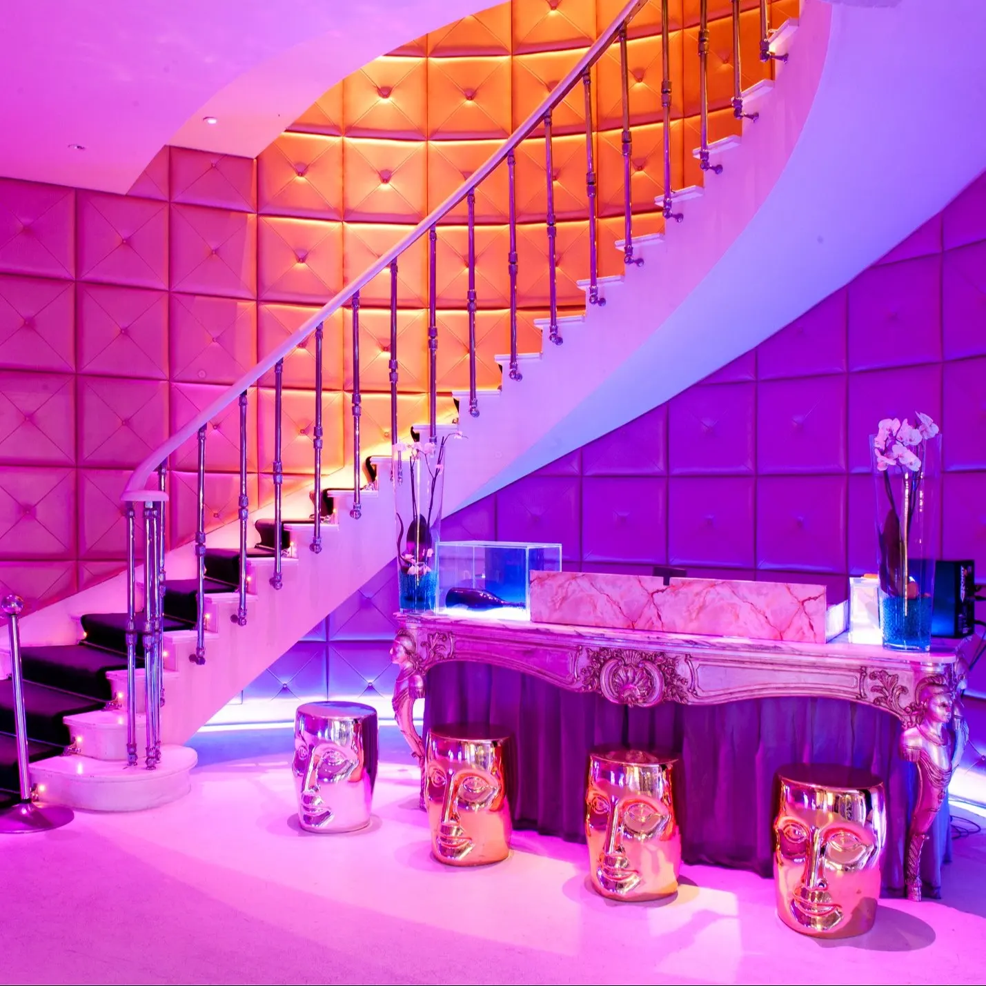 Ramses deslumbra con una decoración vibrante, escaleras elegantes, paredes acolchadas y detalles dorados que crean un ambiente exclusivo y moderno.