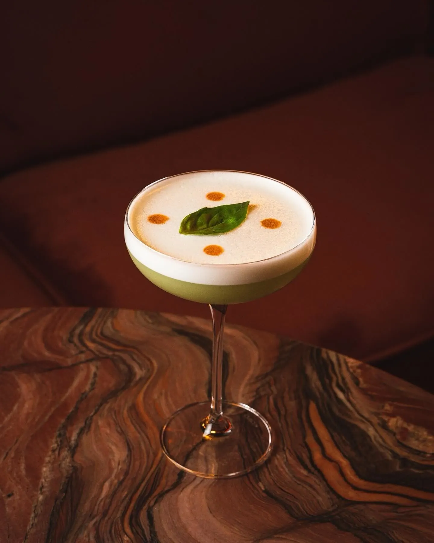 Giselle Dinner Club ofrece una experiencia única donde cada cóctel, como este delicado trago con toque de albahaca, es una obra maestra.