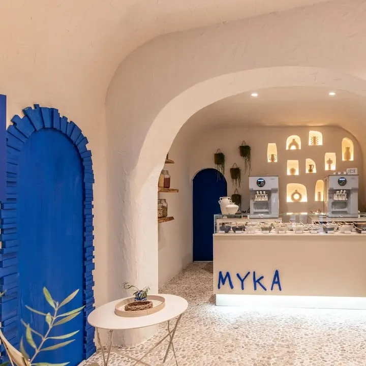 Arcos encalados, suelo de piedra y detalles azules vibrantes en el interior mediterráneo de Myka Ponzano.