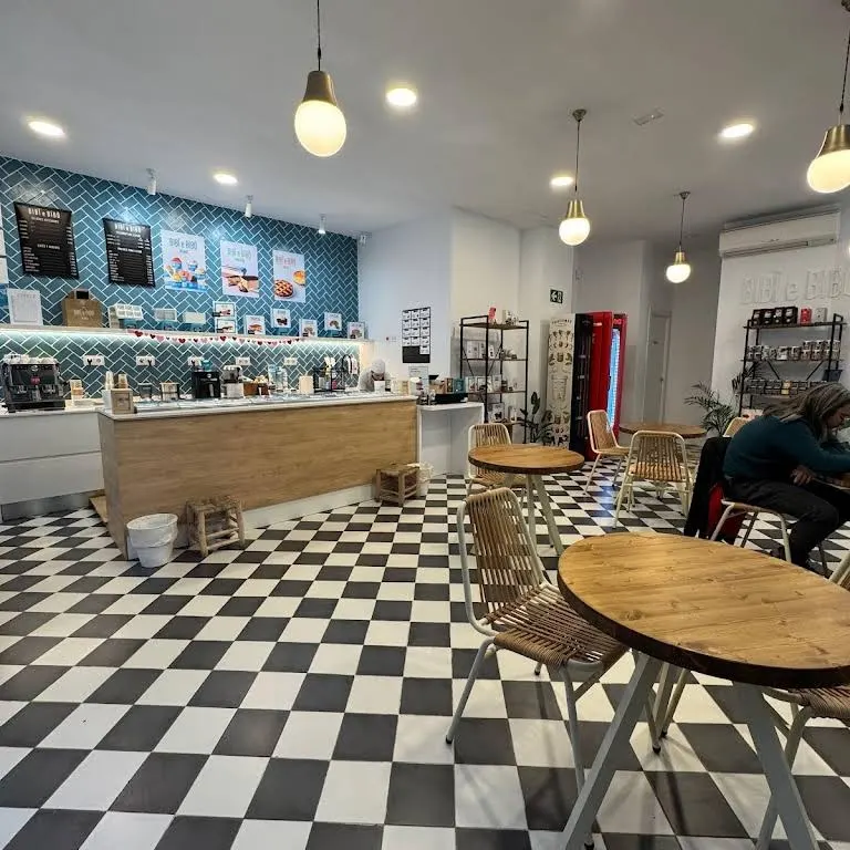 Vista general del interior de Bibi e Bibò Alcalá con suelos en blanco y negro, mesas redondas de madera y un espacio abierto, fresco y acogedor.