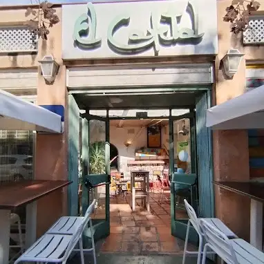 El Cafetal destaca por su entrada rústica con puertas verdes y un interior cálido lleno de mesas coloridas y decoración acogedora.