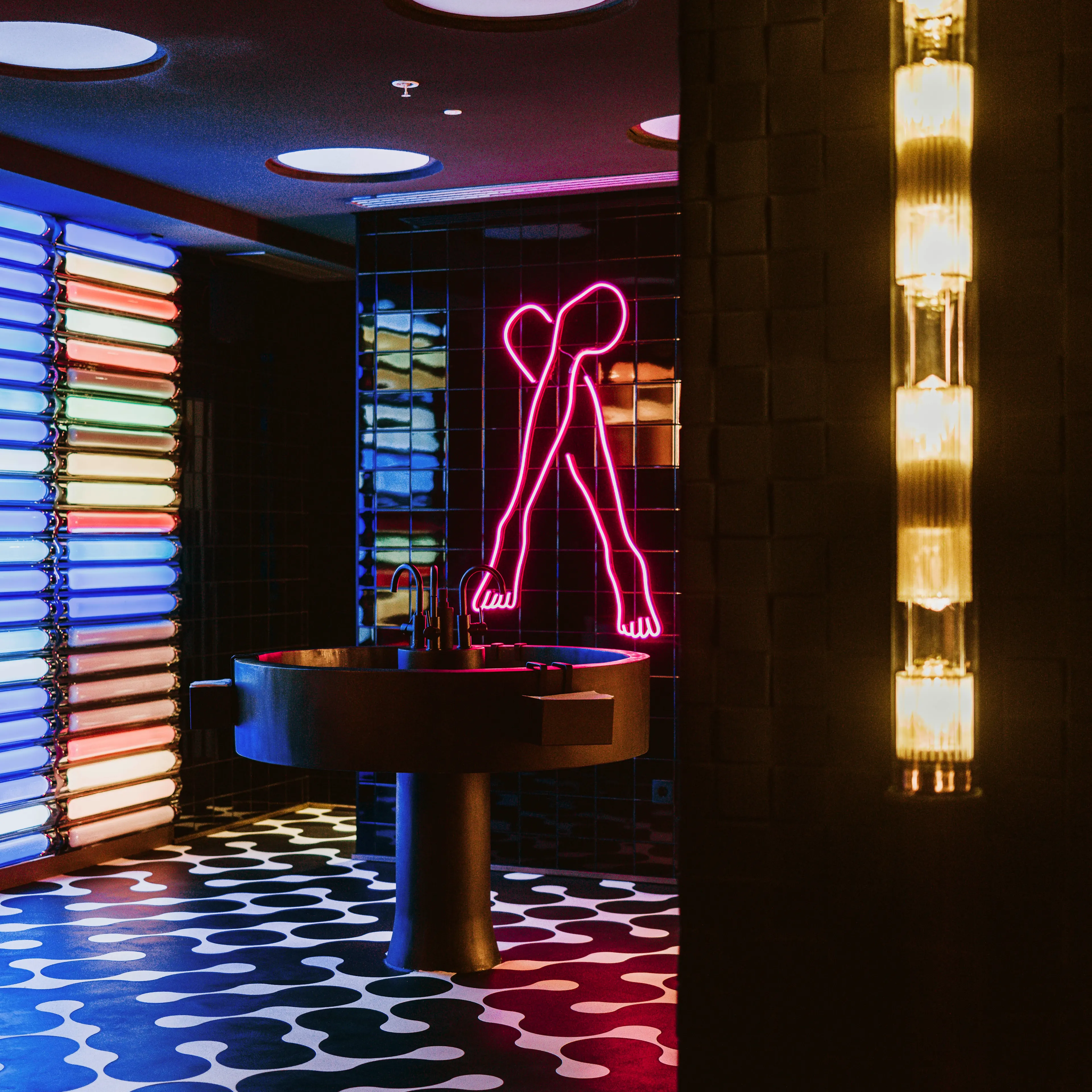 80 Grados Castellana sorprende con un baño psicodélico lleno de neones, lavabos circulares y una pared de luces que parece sacada de una instalación artística.