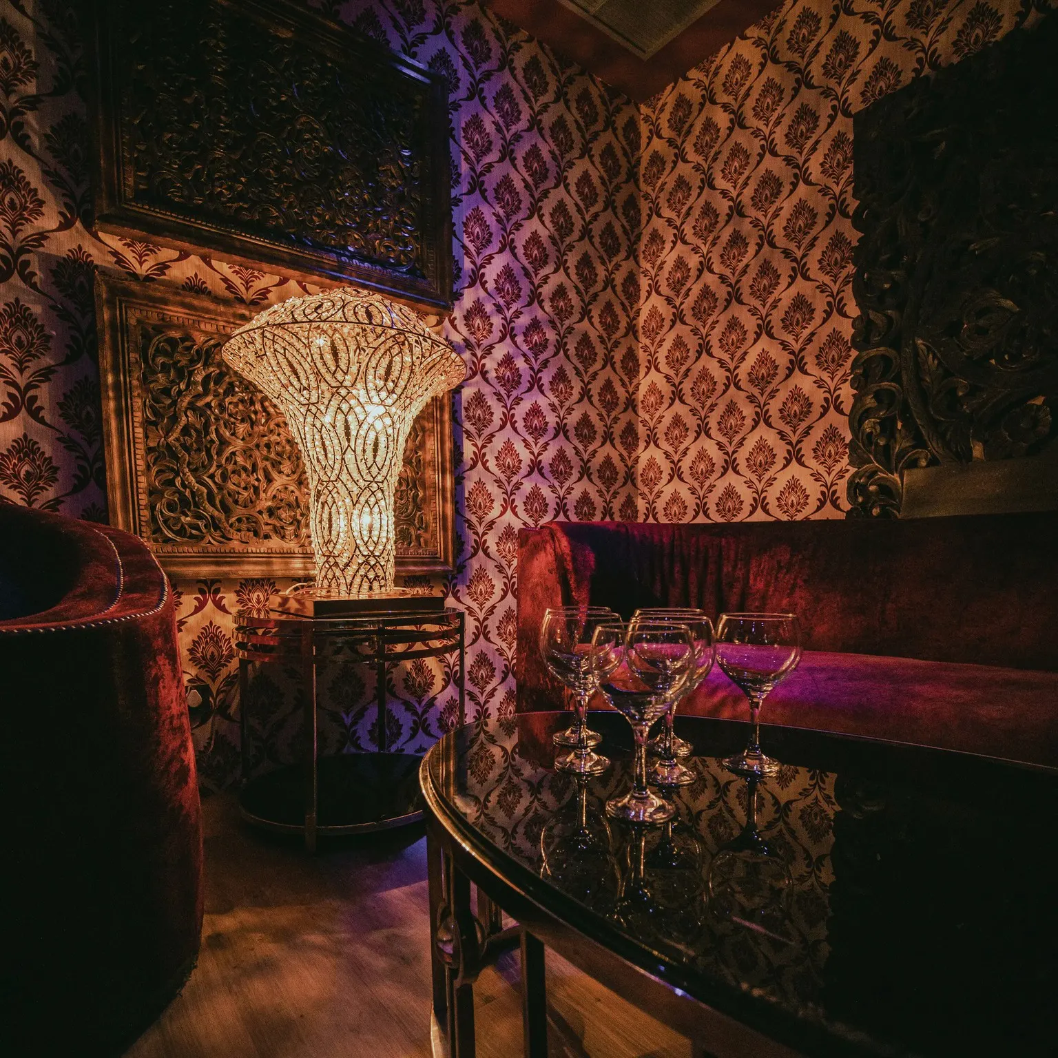 Kumarah con decoración lujosa, lámpara artesanal y sofás de terciopelo, un espacio íntimo ideal para noches exclusivas y elegantes.