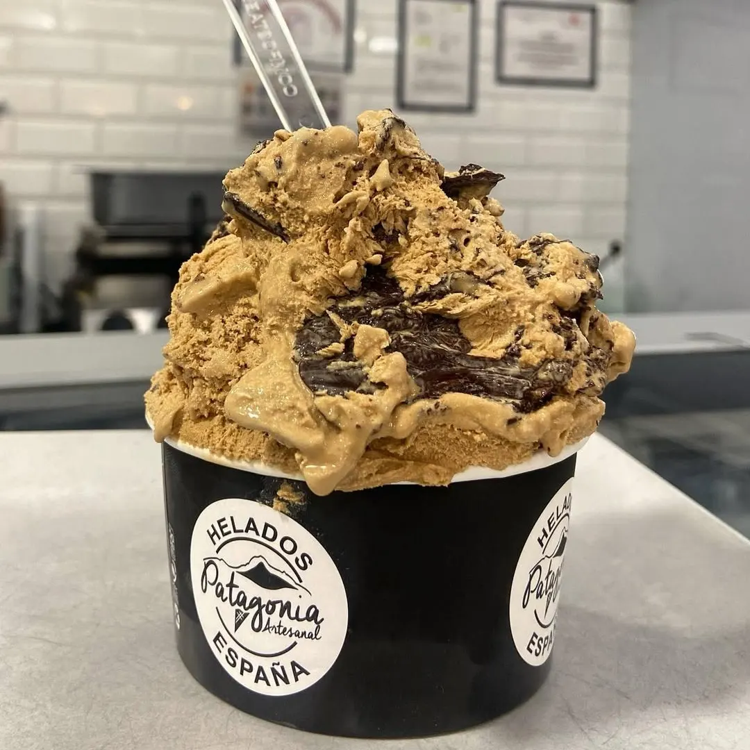 Copa de Helados Patagonia rebosante de dulce de leche y virutas de chocolate. Artesanía heladera servida con generosidad y sabor auténtico.