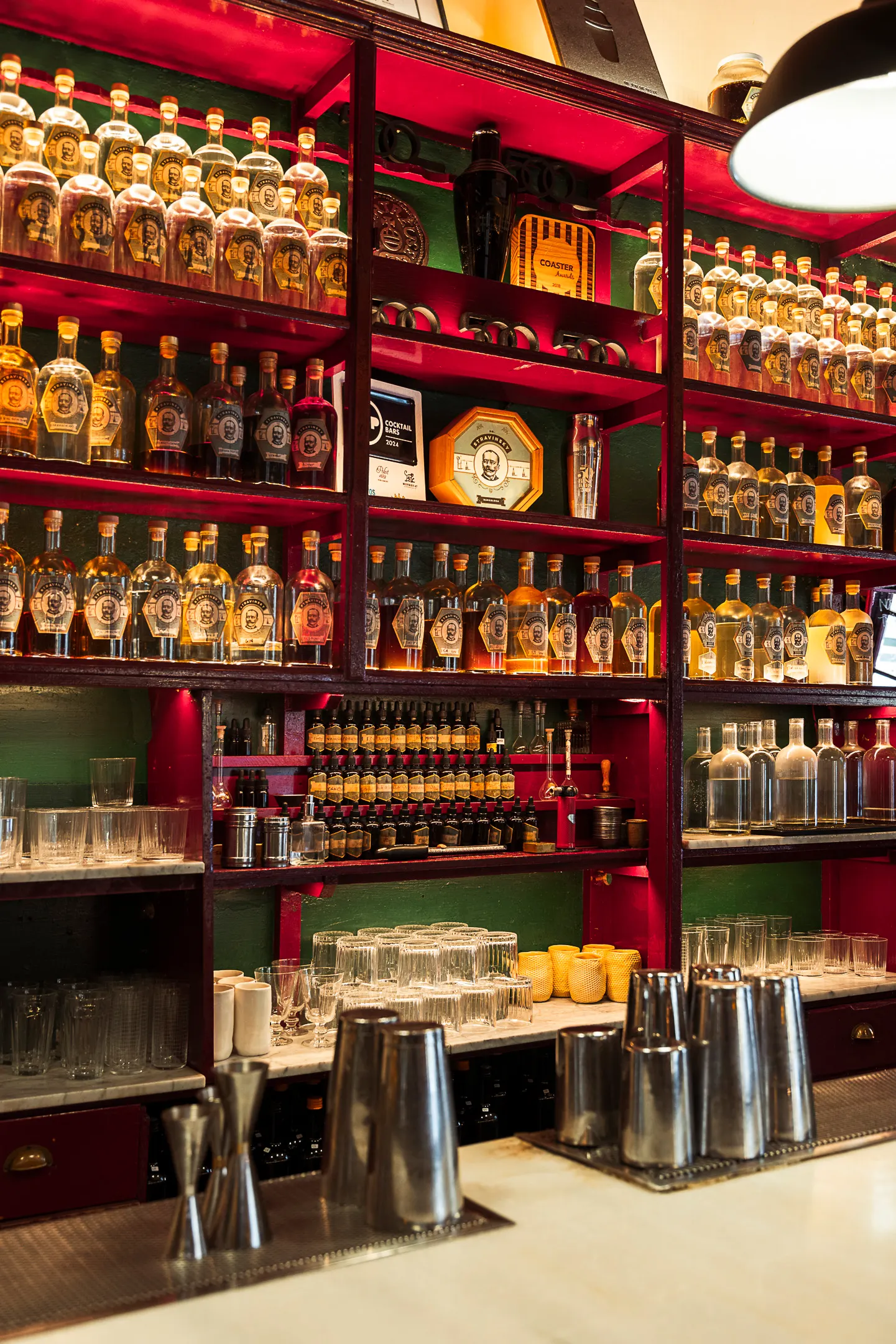 Barra vintage en Dr. Stravinsky, con taburetes altos, botellas organizadas en estanterías y una decoración cálida que evoca un laboratorio antiguo.