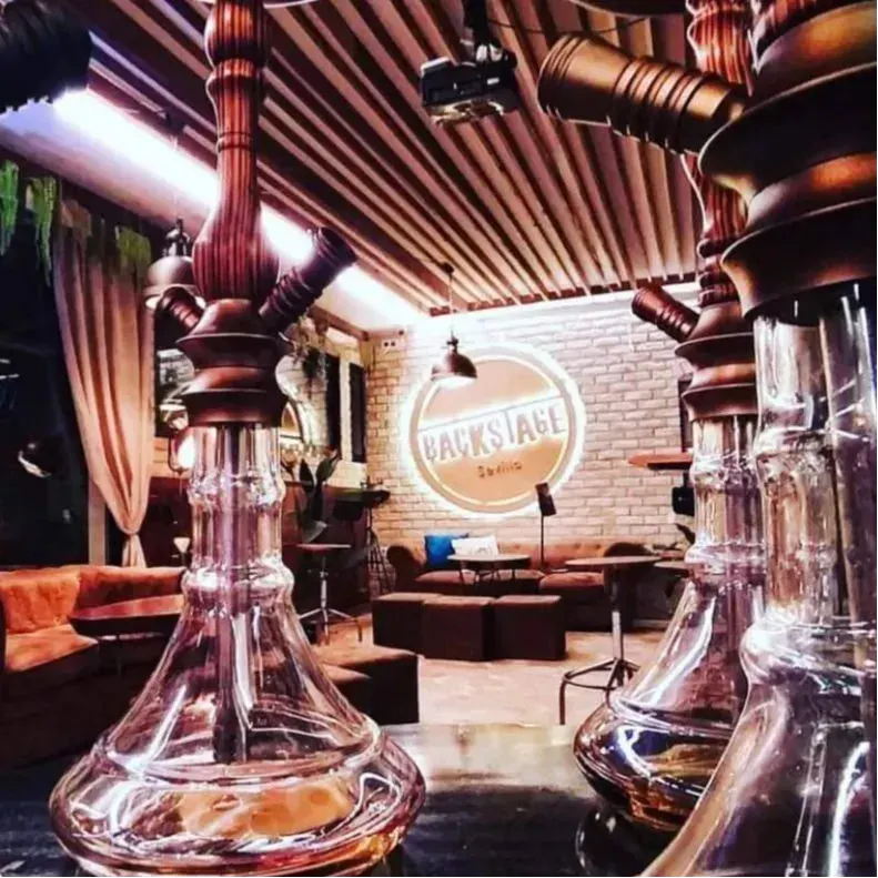 BackStage Sevilla ofrece un espacio acogedor con sofás cómodos, decoración moderna y shishas destacando en un ambiente relajado y elegante.