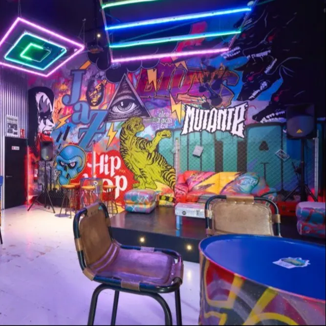 Bar Mutante deslumbra con su vibrante arte urbano, grafitis coloridos, neones futuristas, muebles retro y un escenario que celebra la cultura hip hop.